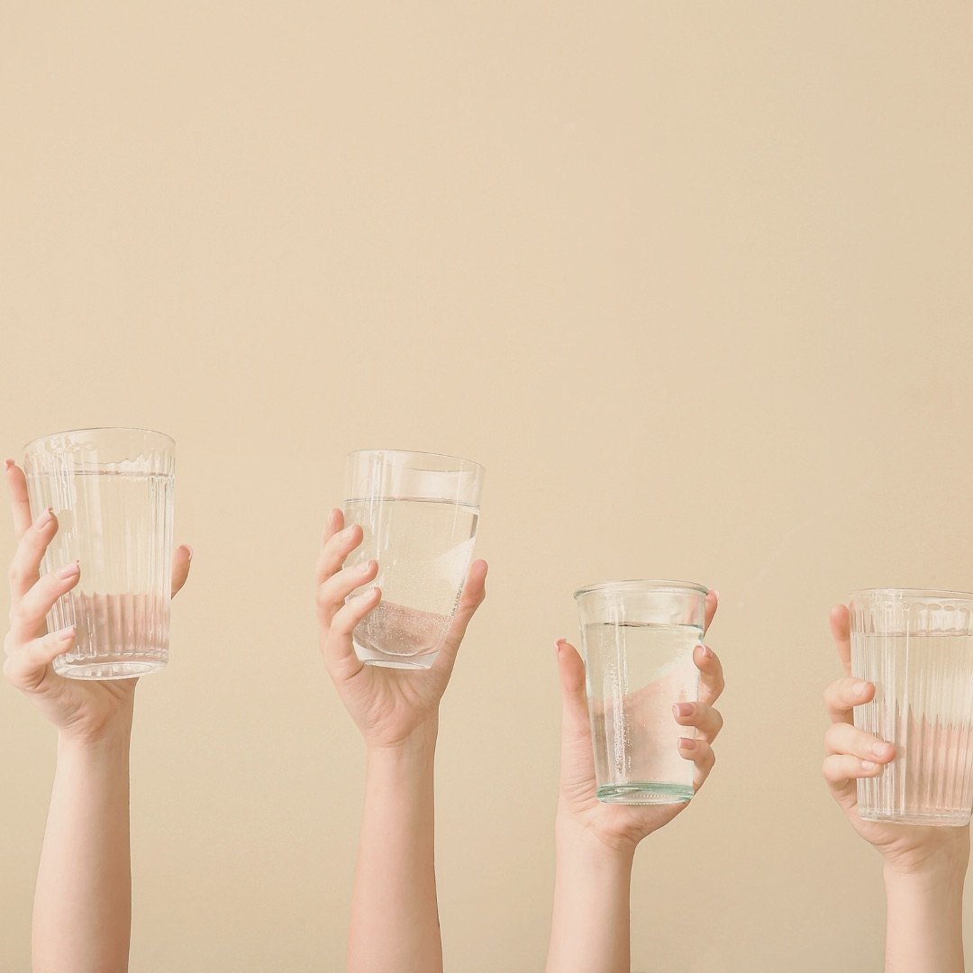 Three glasses of water being raised together